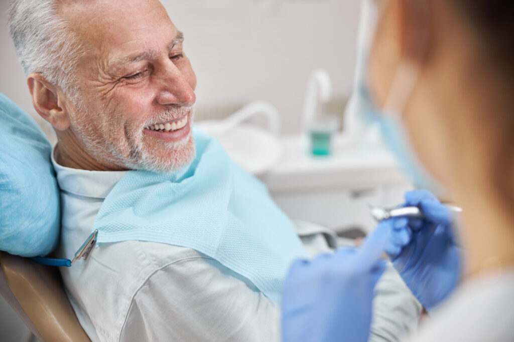 Joyful eldelry man sitting in a dental chair